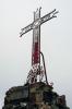 Cruz de hierro en la cumbre de Sant Miquel de les Formigues donde se ven 3 grandes hormigas en su base